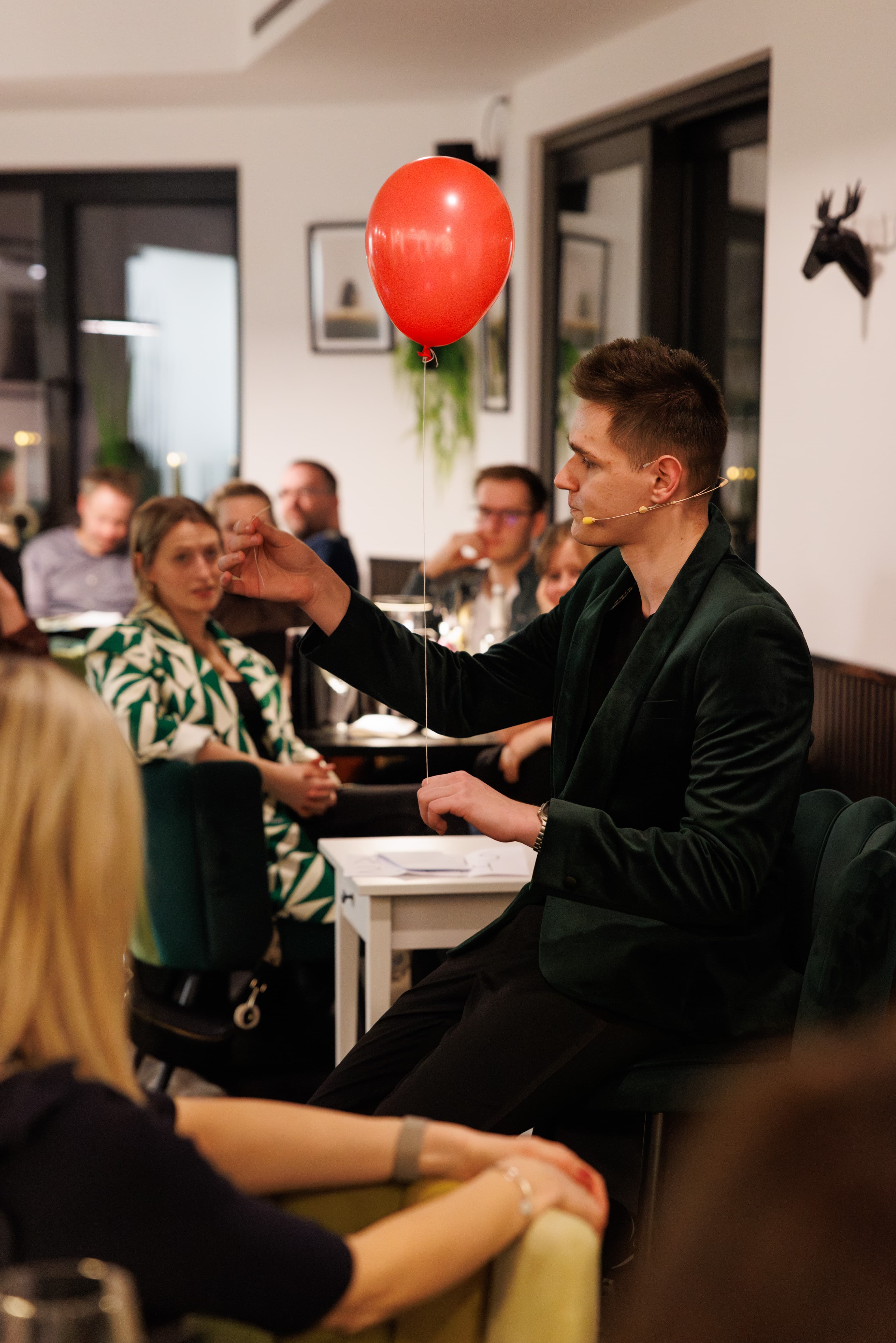 Magicel (Emilian Leber) bei der Tischzauberei mit rotem Luftballon